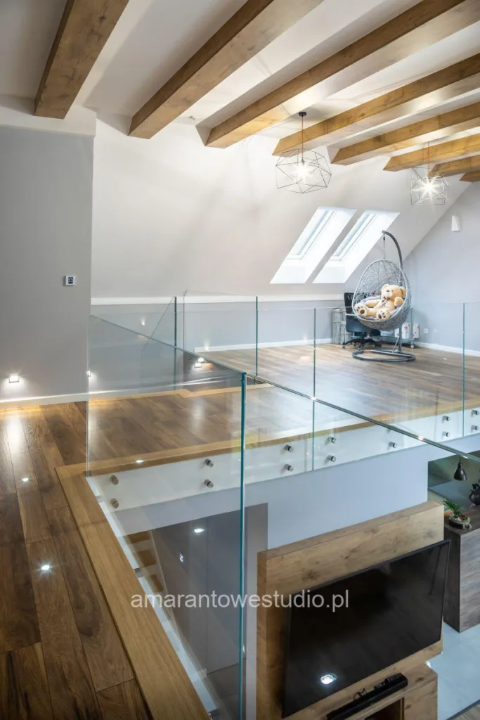 Antresola ze szklaną balustradą, fotelem wiszącym i oknami dachowymi