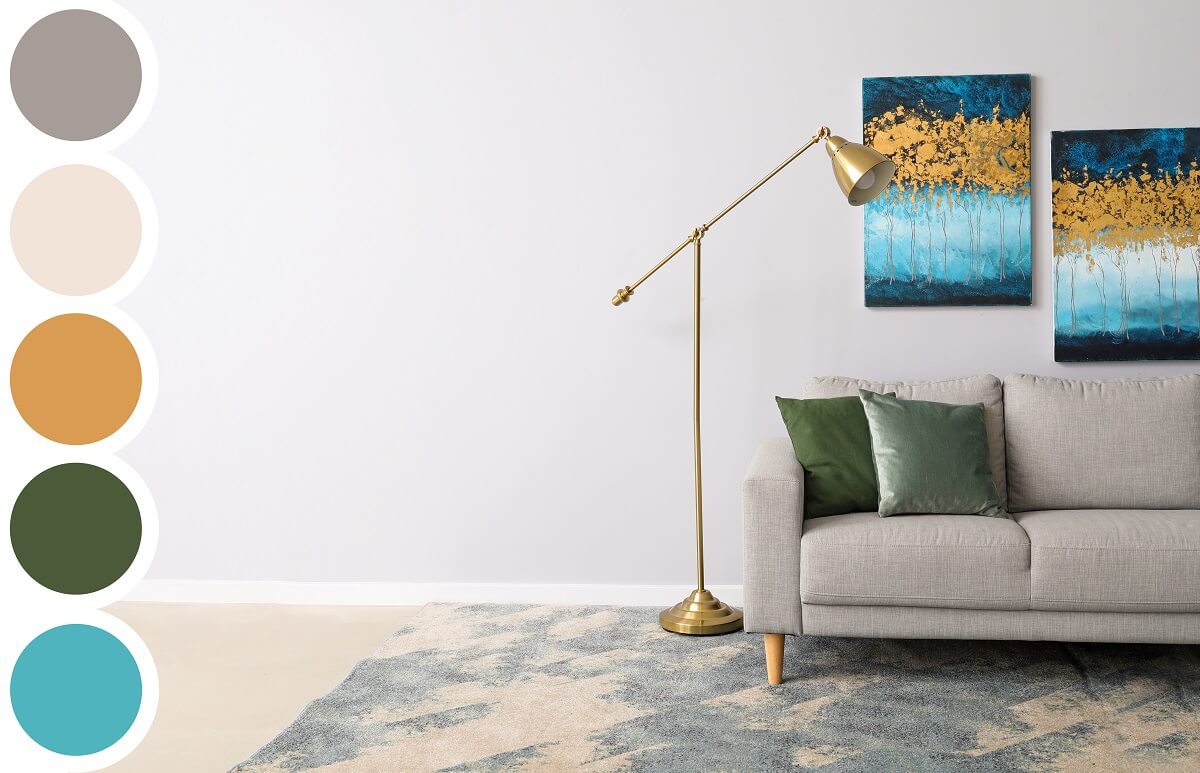 Szara sofa, mosiężna lampa podłogowa i obrazy w salonie, obok paleta kolorów