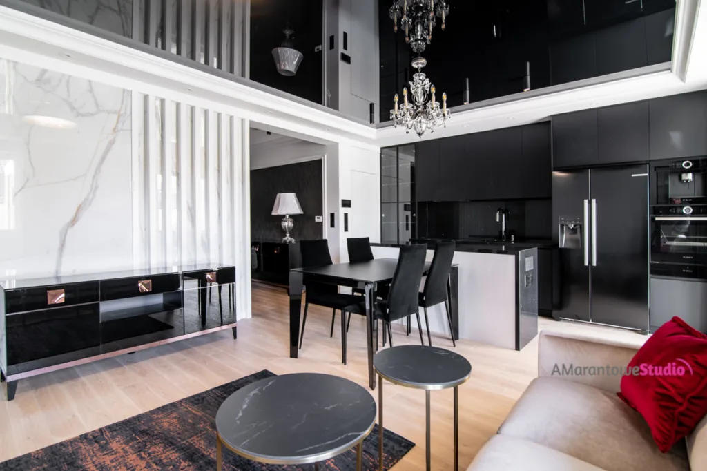 Salon z czarną komodą, ścianą w dekorze marmuru i czarną kuchnią