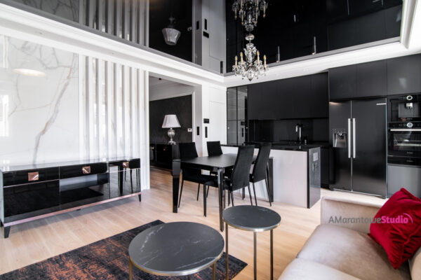 Salon z czarną komodą, ścianą w dekorze marmuru i czarną kuchnią